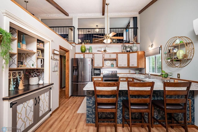 722 Elm St N Unit A8, Fargo, ND 58102 - kitchen with appliances with stainless steel finishes, open shelves, light wood finished floors, a towering ceiling, and a peninsula