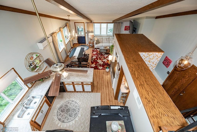 722 Elm St N Unit A8, Fargo, ND 58102 - living area featuring beam ceiling, healthy amount of natural light, wood finished floors, and a textured ceiling