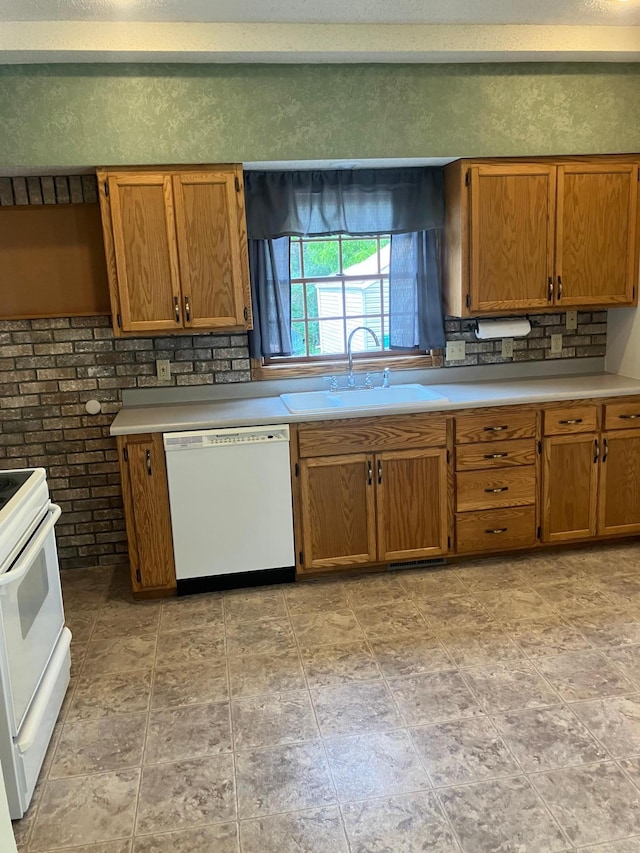 104 River St, Jackson, MN 56143 - kitchen featuring white appliances, brown cabinets, stone finish floors, light countertops, and backsplash