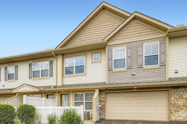 9902 5th Street Ln N, Lake Elmo, MN 55042 - townhome / multi-family property with an attached garage, stone siding, and driveway