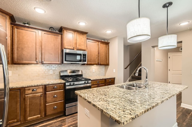 9902 5th Street Ln N, Lake Elmo, MN 55042 - kitchen featuring stainless steel appliances, dark wood finished floors, backsplash, light stone countertops, and an island with sink