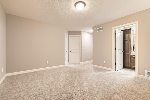 9902 5th Street Ln N, Lake Elmo, MN 55042 - unfurnished bedroom with a textured ceiling, light colored carpet, and ensuite bathroom