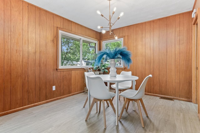 1007 Ingerson Rd, Shoreview, MN 55126 - dining space featuring a chandelier, light wood finished floors, and wooden walls