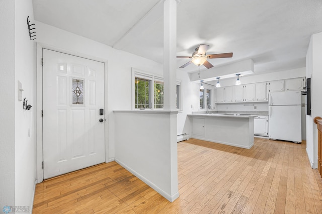 2319 10th St S, Fargo, ND 58103 - kitchen with freestanding refrigerator, a peninsula, ceiling fan, and light wood-type flooring