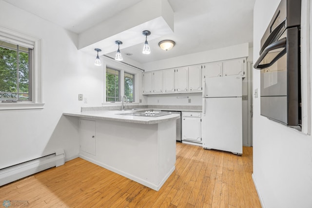 2319 10th St S, Fargo, ND 58103 - kitchen featuring freestanding refrigerator, a baseboard heating unit, white cabinets, a peninsula, and light countertops