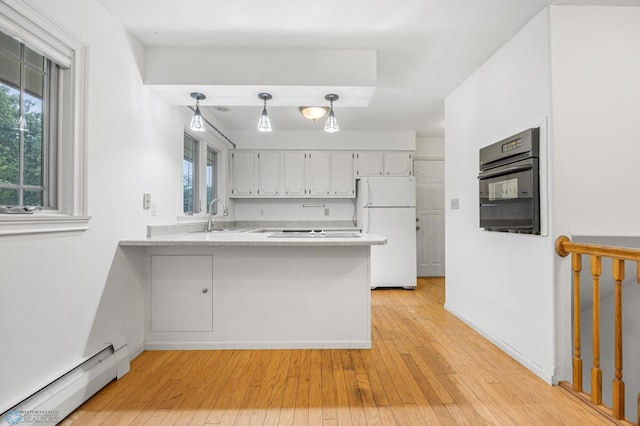 2319 10th St S, Fargo, ND 58103 - kitchen featuring freestanding refrigerator, baseboard heating, black oven, a peninsula, and light countertops