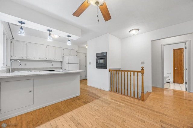 2319 10th St S, Fargo, ND 58103 - kitchen featuring freestanding refrigerator, white cabinetry, a peninsula, black oven, and a ceiling fan
