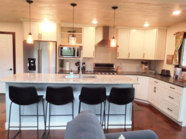 14650 Hilltop Rd, Ashby, MN 56309 - kitchen featuring stainless steel appliances, wall chimney exhaust hood, a breakfast bar, an island with sink, and wood ceiling