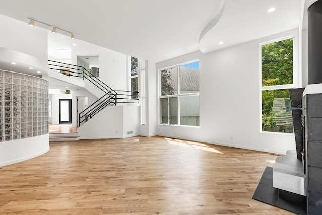 3520 Fairway Ln, Minnetonka, MN 55305 - unfurnished living room with rail lighting, light wood-style flooring, stairs, and recessed lighting