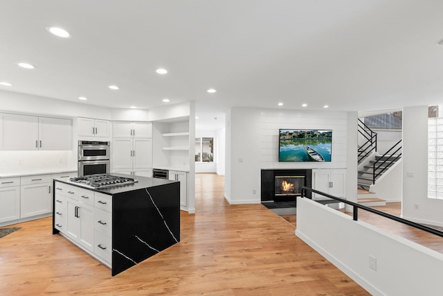 3520 Fairway Ln, Minnetonka, MN 55305 - kitchen with stainless steel appliances, a fireplace, white cabinets, a kitchen island, and recessed lighting