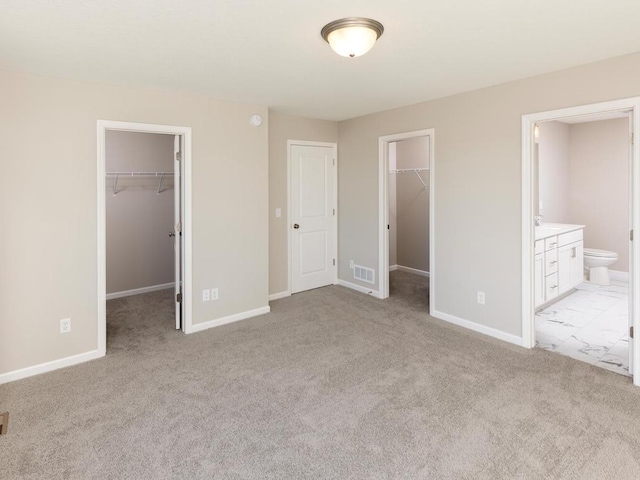 3237 Jandura Ave NE, Saint Michael, MN 55376 - unfurnished bedroom with a walk in closet, a closet, light colored carpet, and connected bathroom