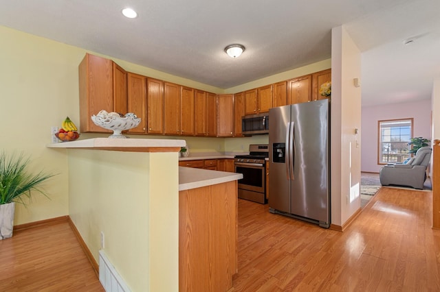 114006 Hundertmark Rd, Chaska, MN 55318 - kitchen featuring stainless steel appliances, light wood-style floors, light countertops, a peninsula, and recessed lighting