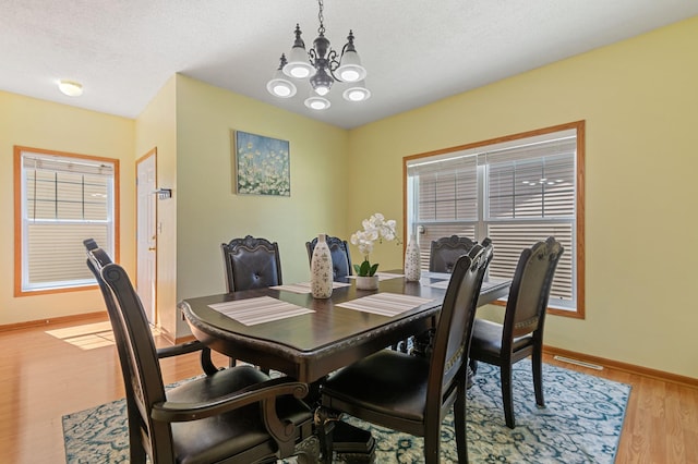 114006 Hundertmark Rd, Chaska, MN 55318 - dining space with a chandelier, light wood finished floors, and a textured ceiling
