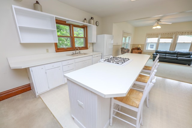 1122 Fillmore St, Alexandria, MN 56308 - kitchen featuring white appliances, white cabinets, a center island, and healthy amount of natural light