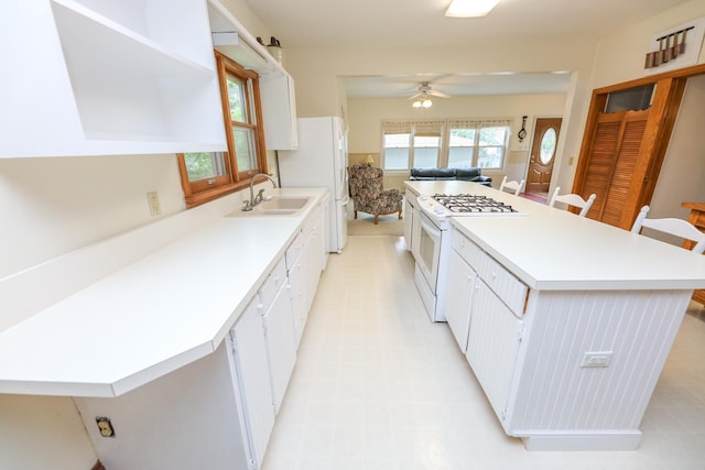 1122 Fillmore St, Alexandria, MN 56308 - kitchen with white appliances, ceiling fan, open shelves, white cabinetry, and light flooring
