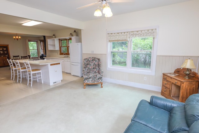 1122 Fillmore St, Alexandria, MN 56308 - living area with wainscoting, a ceiling fan, light colored carpet, and a chandelier