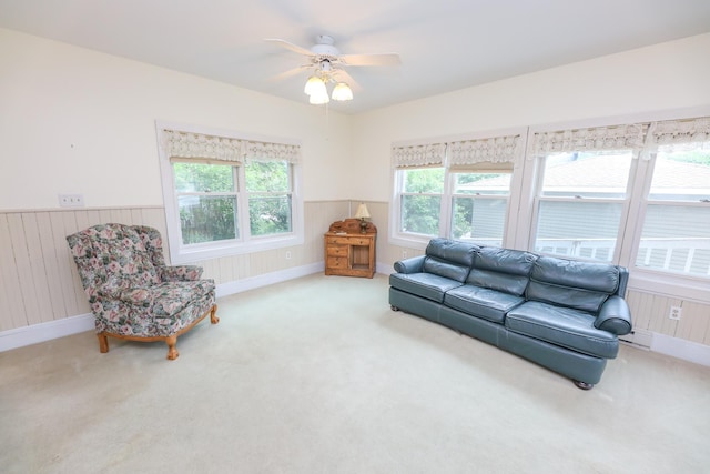 1122 Fillmore St, Alexandria, MN 56308 - living room featuring carpet floors, a wainscoted wall, ceiling fan, and wood walls