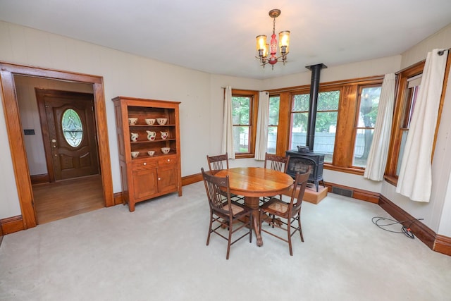 1122 Fillmore St, Alexandria, MN 56308 - dining area featuring a wood stove, light carpet, and a chandelier