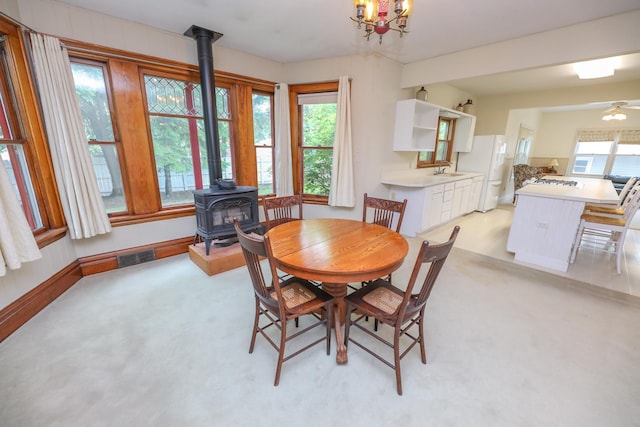 1122 Fillmore St, Alexandria, MN 56308 - dining space with a wood stove, light carpet, and a chandelier