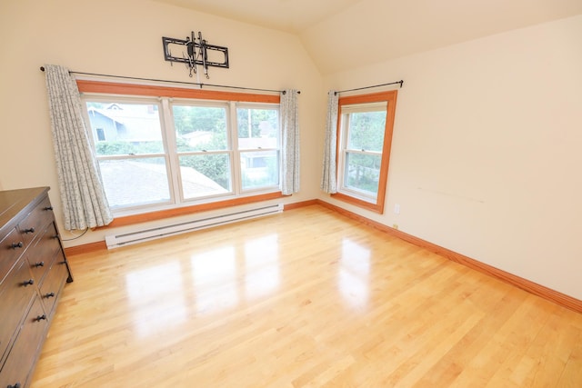1122 Fillmore St, Alexandria, MN 56308 - unfurnished dining area with a baseboard heating unit, light wood finished floors, and vaulted ceiling