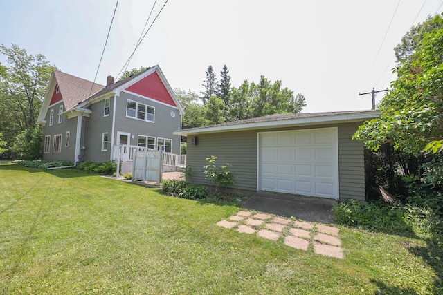 1122 Fillmore St, Alexandria, MN 56308 - rear view of house featuring a garage, driveway, a yard, and an outbuilding
