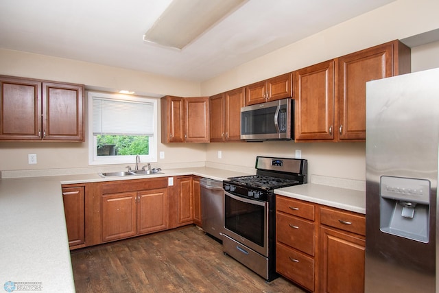 634 11th St N, Moorhead, MN 56560 - kitchen with appliances with stainless steel finishes, dark wood-type flooring, brown cabinets, and light countertops