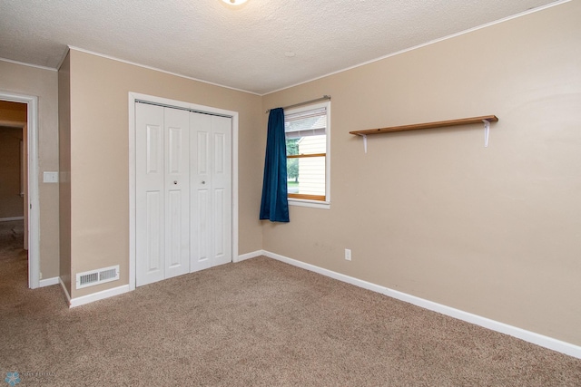 634 11th St N, Moorhead, MN 56560 - unfurnished bedroom featuring carpet floors, a textured ceiling, crown molding, and a closet