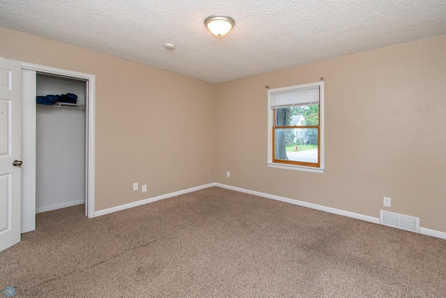 634 11th St N, Moorhead, MN 56560 - unfurnished bedroom with carpet flooring, a closet, and a textured ceiling