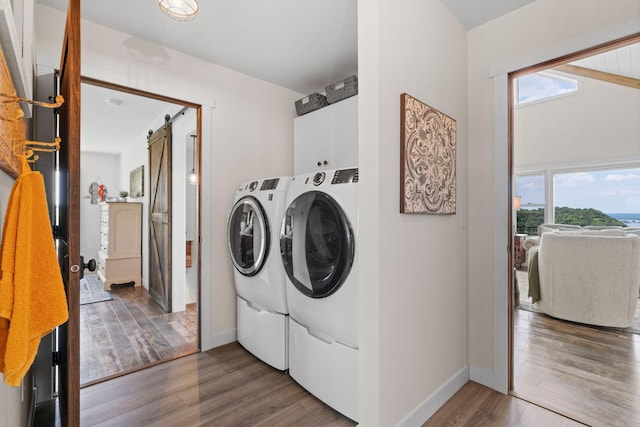 26887 709th St, Lake City, MN 55041 - washroom with a barn door, washer and clothes dryer, cabinet space, and wood finished floors