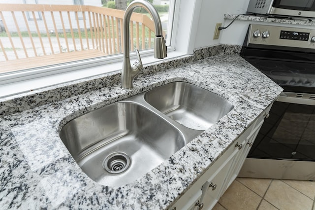 525 Warren Ave, Spring Valley, MN 55975 - kitchen view of appliances with stainless steel finishes, white cabinetry, and light stone counters