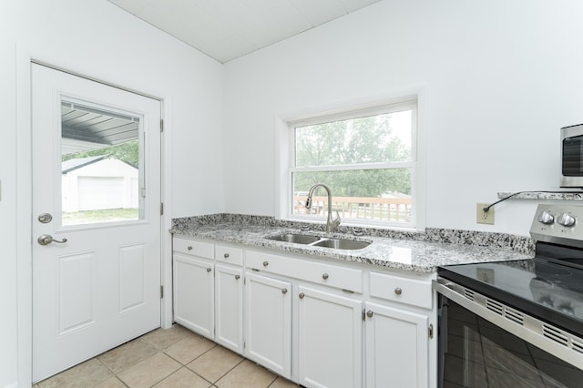 525 Warren Ave, Spring Valley, MN 55975 - kitchen featuring stainless steel appliances, white cabinetry, light tile patterned floors, and light stone countertops