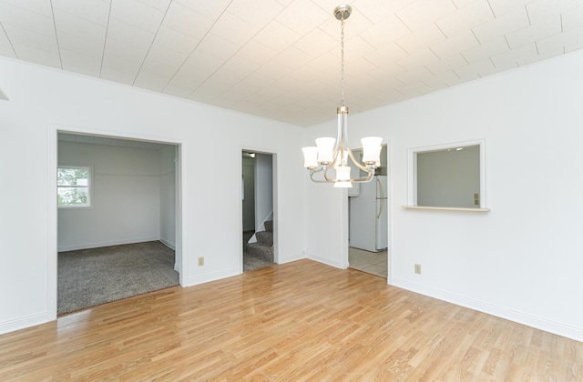 525 Warren Ave, Spring Valley, MN 55975 - unfurnished room with stairs, a chandelier, and light wood-type flooring