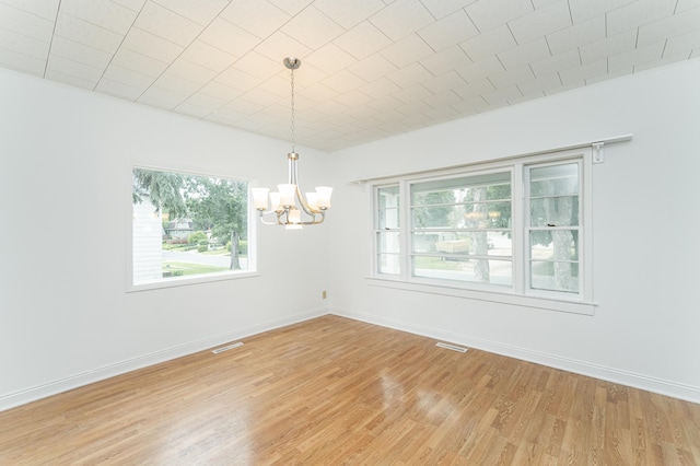 525 Warren Ave, Spring Valley, MN 55975 - spare room featuring a chandelier, healthy amount of natural light, and light wood-type flooring