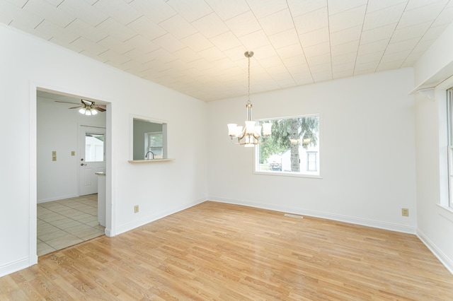 525 Warren Ave, Spring Valley, MN 55975 - spare room featuring a chandelier, plenty of natural light, light wood-type flooring, and a ceiling fan