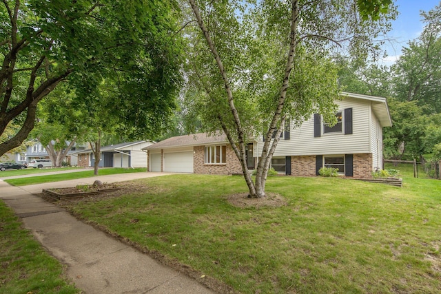 14136 Germane Ave, Apple Valley, MN 55124 - split level home featuring an attached garage, concrete driveway, brick siding, and a front yard