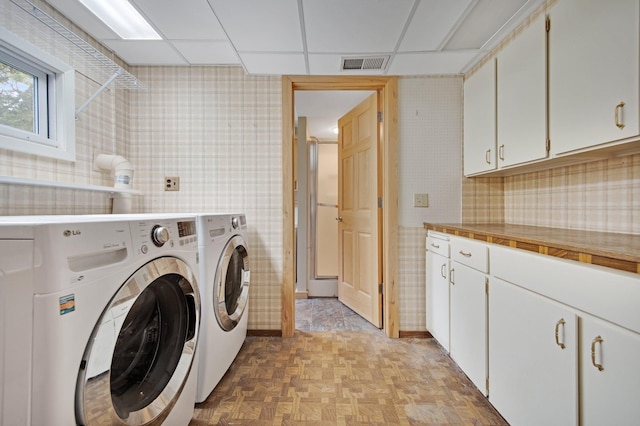 14136 Germane Ave, Apple Valley, MN 55124 - laundry room featuring wallpapered walls, washing machine and dryer, and cabinet space