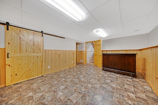 14136 Germane Ave, Apple Valley, MN 55124 - finished basement featuring wooden walls, stairs, a wainscoted wall, a barn door, and stone finish flooring