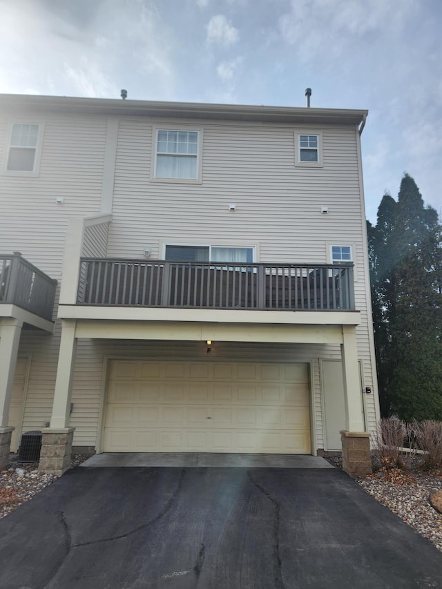 11330 Davenport Cir NE Unit F, Blaine, MN 55449 - back of house with driveway, an attached garage, and a balcony