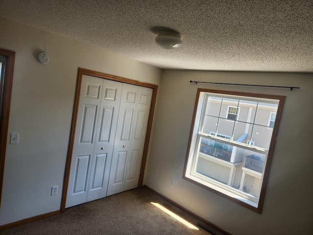 11330 Davenport Cir NE Unit F, Blaine, MN 55449 - unfurnished bedroom featuring carpet, a closet, and a textured ceiling