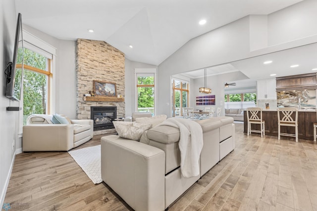 3020 26th Ave S, Fargo, ND 58103 - living room featuring light wood-type flooring, a stone fireplace, lofted ceiling, and recessed lighting