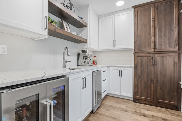 3020 26th Ave S, Fargo, ND 58103 - kitchen with wine cooler, open shelves, light wood-style floors, light stone counters, and white cabinets