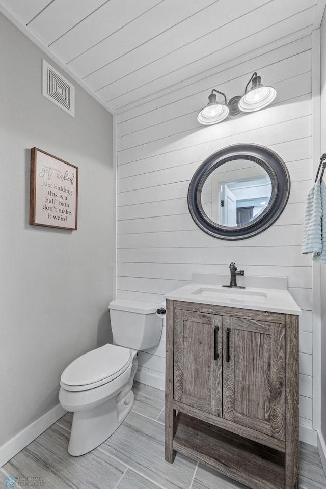 3020 26th Ave S, Fargo, ND 58103 - bathroom featuring vanity, wood walls, and wood finished floors
