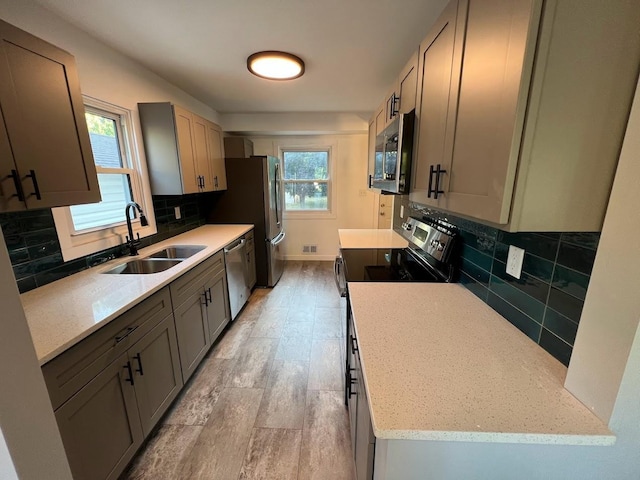 5923 Hodgson Rd, Shoreview, MN 55126 - kitchen featuring appliances with stainless steel finishes, light wood finished floors, tasteful backsplash, and gray cabinets