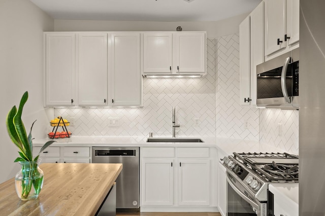 3000 Raleigh Ave Unit 307, Saint Louis Park, MN 55416 - kitchen featuring appliances with stainless steel finishes, backsplash, light countertops, and white cabinetry
