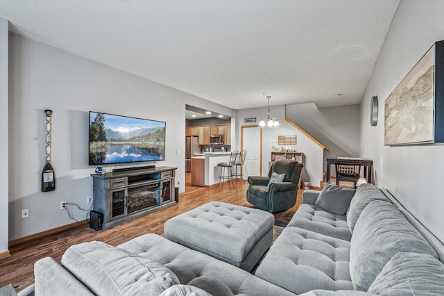 11122 Aberdeen St NE Unit C, Blaine, MN 55449 - living area featuring a chandelier, light wood-type flooring, and a textured ceiling