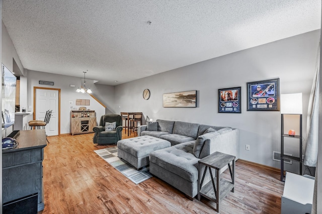 11122 Aberdeen St NE Unit C, Blaine, MN 55449 - living area featuring light wood-style flooring, a chandelier, and a textured ceiling