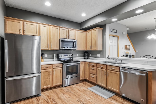 11122 Aberdeen St NE Unit C, Blaine, MN 55449 - kitchen with stainless steel appliances, a peninsula, light wood-type flooring, light countertops, and recessed lighting