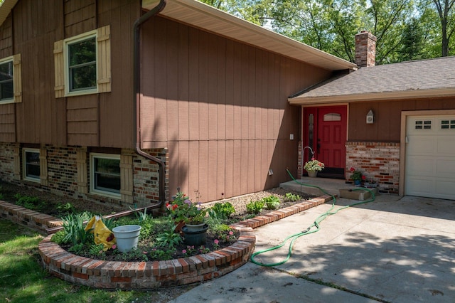 13587 70th Ave N, Maple Grove, MN 55311 - property entrance with brick siding, a chimney, concrete driveway, and a garage