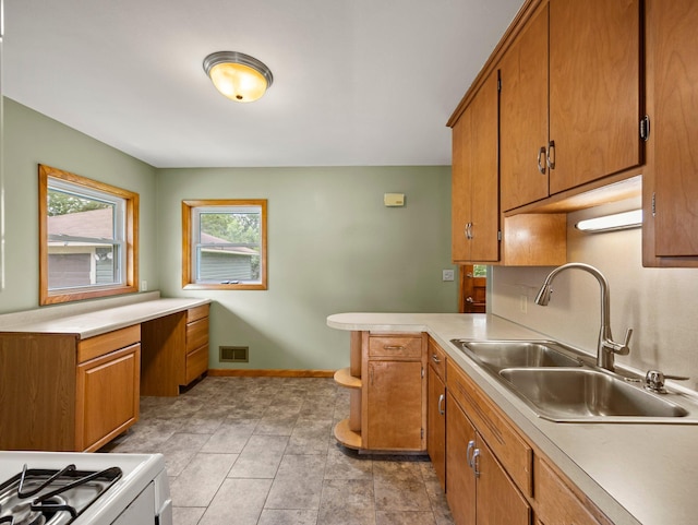 7920 Clinton Ave S, Bloomington, MN 55420 - kitchen with light countertops, a peninsula, brown cabinetry, stove, and a desk