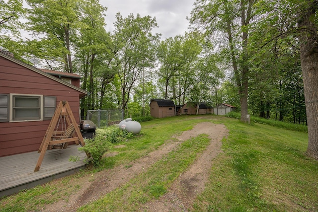 2170 County 5 NW, Hackensack, MN 56452 - view of green lawn with a storage unit, dirt driveway, a wooden deck, and view of scattered trees
